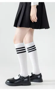 Nahaufnahme der atmungsaktiven weißen Wadensocken mit klassischen drei schwarzen Streifen.