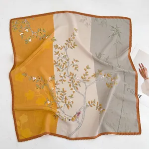 Detail exquis de foulard en soie vintage avec imprime floral et d'oiseau et bordure.