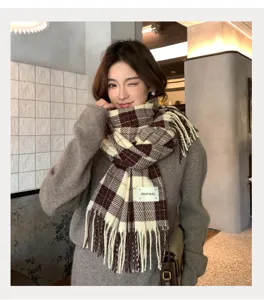 Gros plan d'une écharpe d'hiver douillette à motif écossais et franges, texture douce.