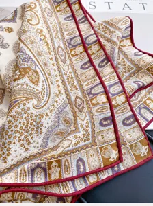 Silk wool square scarf detail view showcasing exquisite paisley pattern and elegant red piped border.