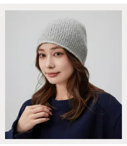 Détail de bonnet en tricot mélange de laine grise, texture douce et ajustement confortable.