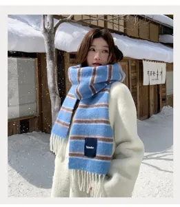Detailed view of blue and brown striped wool blend scarf worn in snowy winter scene.