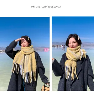 Detail view of a cozy yellow and grey fluffy winter scarf with tassels for cold weather fashion.