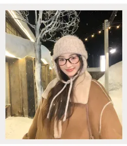Detalle del acogedor gorro de punto con orejeras en un paisaje nevado de invierno al aire libre.