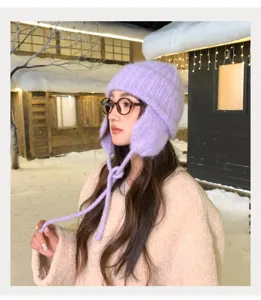 Gorro de punto de invierno coreano con orejeras en suave morado, detalle de estilo cálido.