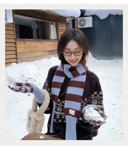 Vue détaillée de l'ensemble écharpe et gants tricotés rayés d'hiver pour femme élégante.