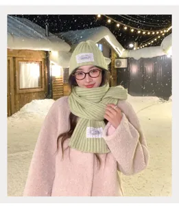 Detail view of the winter knitted beanie and scarf set in light green with lace patch decor.