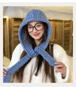 Primo piano dettagliato di una sciarpa con cappuccio blu lavorata a maglia spessa.