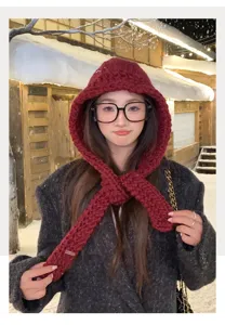 Dettaglio della sciarpa con cappuccio in maglia grossa indossata dalla modella nella neve.