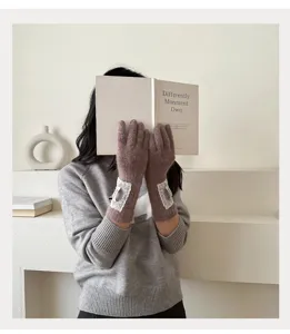 Nahaufnahme koreanischer Strickhandschuhe in Braunrosa mit eleganten weißen Spitzenbündchen.
