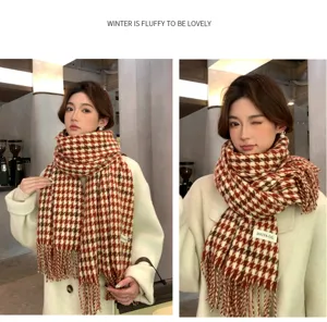 Detailed view of the red and white houndstooth winter scarf, soft tassel knit material.