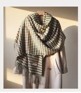 Close-up detail of the classic houndstooth scarf with cozy fringes and textured wool fabric.