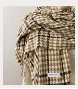 Detailed view of women's autumn winter plaid tassel scarf with classic houndstooth pattern.