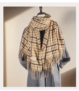 Close-up detail of cozy winter plaid fringe scarf draped elegantly on a display mannequin.