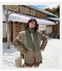 Detailansicht des kuscheligen grünen Winter-Stoffschals bei einem malerischen Outdoor-Shooting.