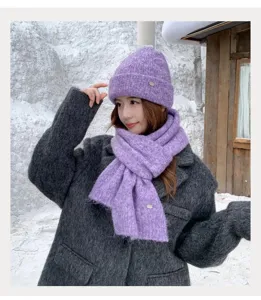 Primer plano detallado del conjunto de gorro y bufanda de punto morado en la nieve invernal.