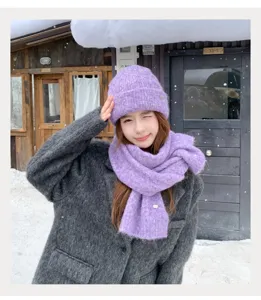 Detalle de conjunto de gorro y bufanda de punto morado de invierno en la nieve, cálido.