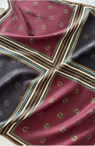 Elegant foulard carre en melange de soie et laine avec des panneaux geometriques et floraux.