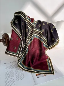 Gros-plan d'écharpe de luxe en soie laine avec bordure géométrique élégante et motif de feuilles.