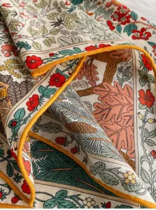 Primo piano di un lussuoso foulard quadrato in seta e lana con motivo botanico e orlo giallo.