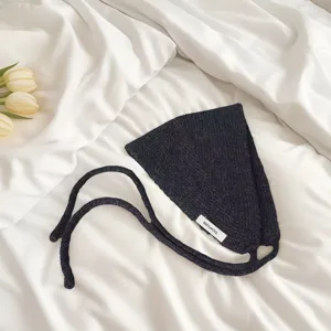 Detailed view of the black wool knitted headscarf showing soft texture and quality label.