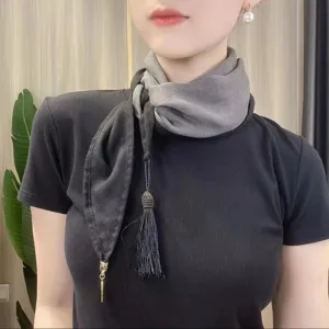 Two-tone silk scarf with tassel pendant, elegant neckwear detail for stylish everyday wear.