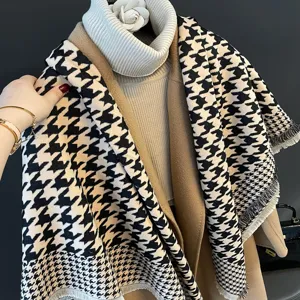 Vue détaillée d'une écharpe chic en motif pied-de-poule noir et blanc bien drapée.