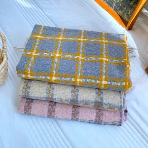 Primo piano dettagliato di sciarpe a quadri invernali con morbida texture e tessuto caldo.