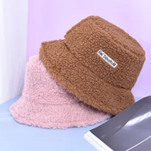 Detailopname van zachte pluche vissershoeden in bruin en roze met een wollige textuur.