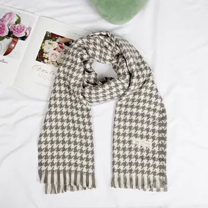 Classic grey and white houndstooth scarf detail, featuring soft cashmere feel and chic fringe ends.