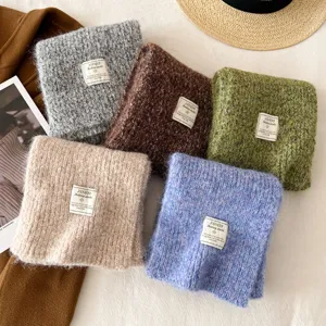 Detailed showcase of soft winter knitted scarves in assorted colors with labels. Cozy texture.