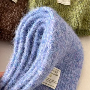 Close-up of soft fluffy knitted winter scarf showing delicate texture and woven details.