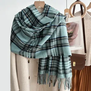 Detailed view of soft blue tartan scarf with elegant plaid pattern and cozy fringe hem.