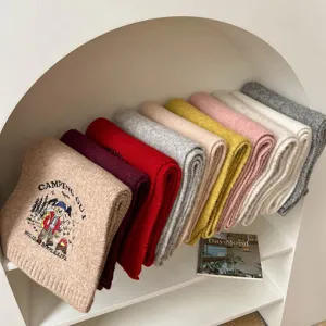 Knitted wool scarf detail, cozy winter warm colorful scarf featuring cute bear embroidery.