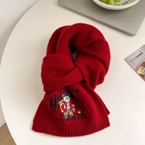 Red knitted winter scarf with cute embroidered bear design, warm and cozy for cold weather.