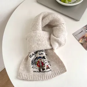 Cozy beige knit scarf featuring a cute camping bear embroidery and warm winter style details.
