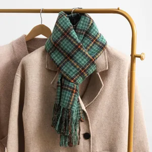 Retro green plaid winter scarf detail featuring cozy fabric and classic tassel fringe.