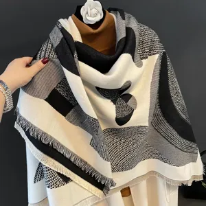 Primo piano dettagliato della morbida scialle sciarpa invernale geometrica bianco e nero.