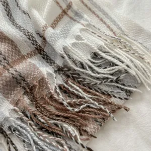 Cozy autumn winter plaid scarf detail with soft fringe, stylish warm cashmere feel accessory.