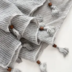 Grey linen cotton scarf detail texture featuring wooden beads and elegant tassels close up