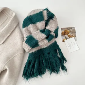 Close-up detail of the green and white striped knit fringe scarf, soft fuzzy texture, winter warm accessory.