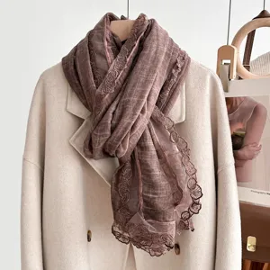 Brown lace trim scarf detail showing soft fabric and elegant floral pattern edge.