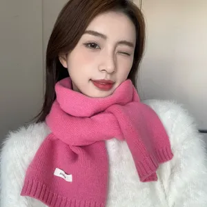 Gedetailleerde close-up van een gezellige roze gebreide winterscarf met zachte textuur.