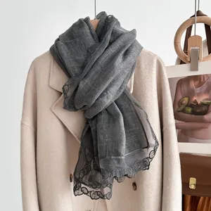 Grey scarf detail showcasing exquisite lace trim and soft fabric texture for autumn and winter.