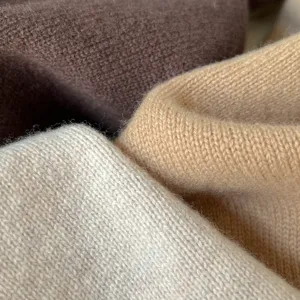 Gedetailleerde close-up van zachte gebreide wollen sjaal stof met fijne textuur.