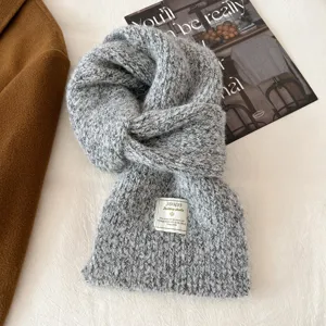 Grey knitted winter scarf detail, soft wool blend neck warmer for cozy cold weather style.