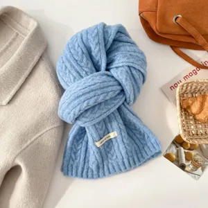 Detail shot of light blue cable knit wool scarf texture, elegant winter fashion accessory.