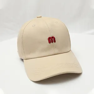 Beige baseball cap with red embroidered m letter, casual fashion sun hat for men and women.