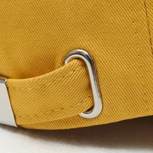 Close-up detail van een gele honkbalpet met verstelbare stoffen band en metalen gespring
