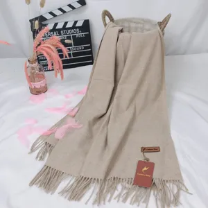 Solid color imitation cashmere scarf with tassels, warm winter shawl for women in beige detail.